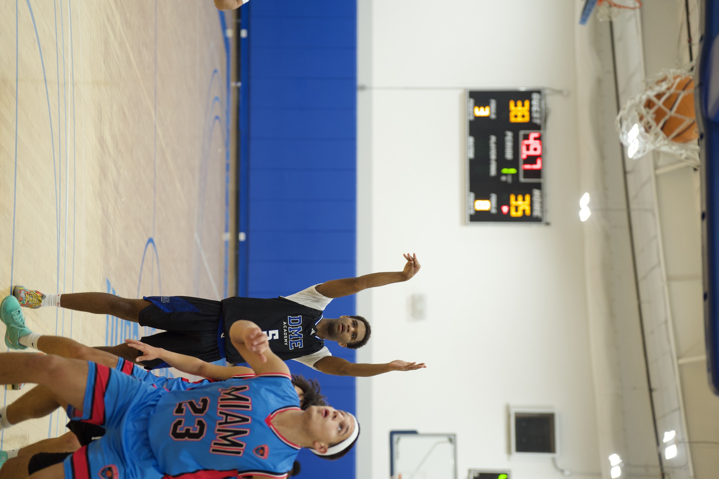 Basketball player celebrating as ball drops through net during competitive game