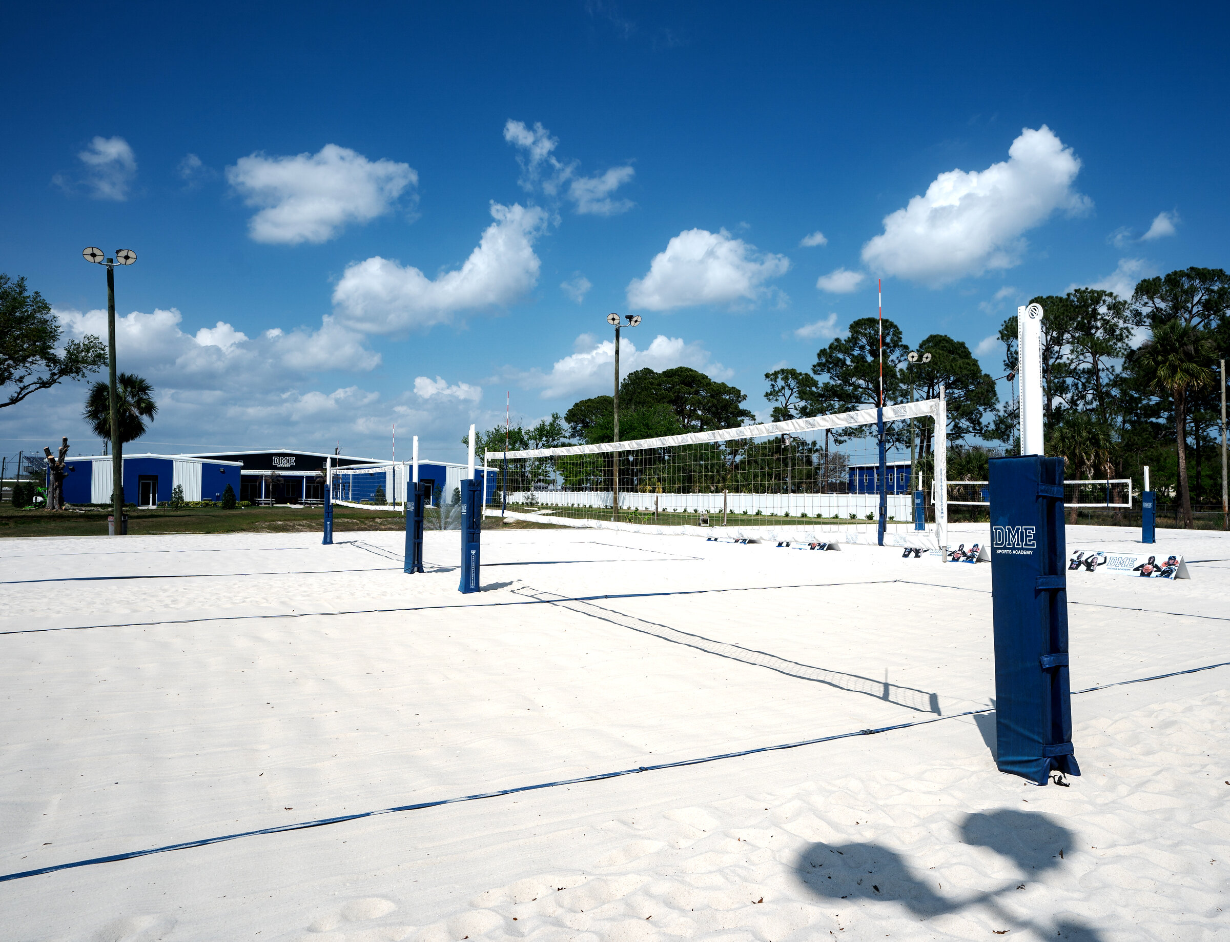 Beach volleyball courts with DME Academy building