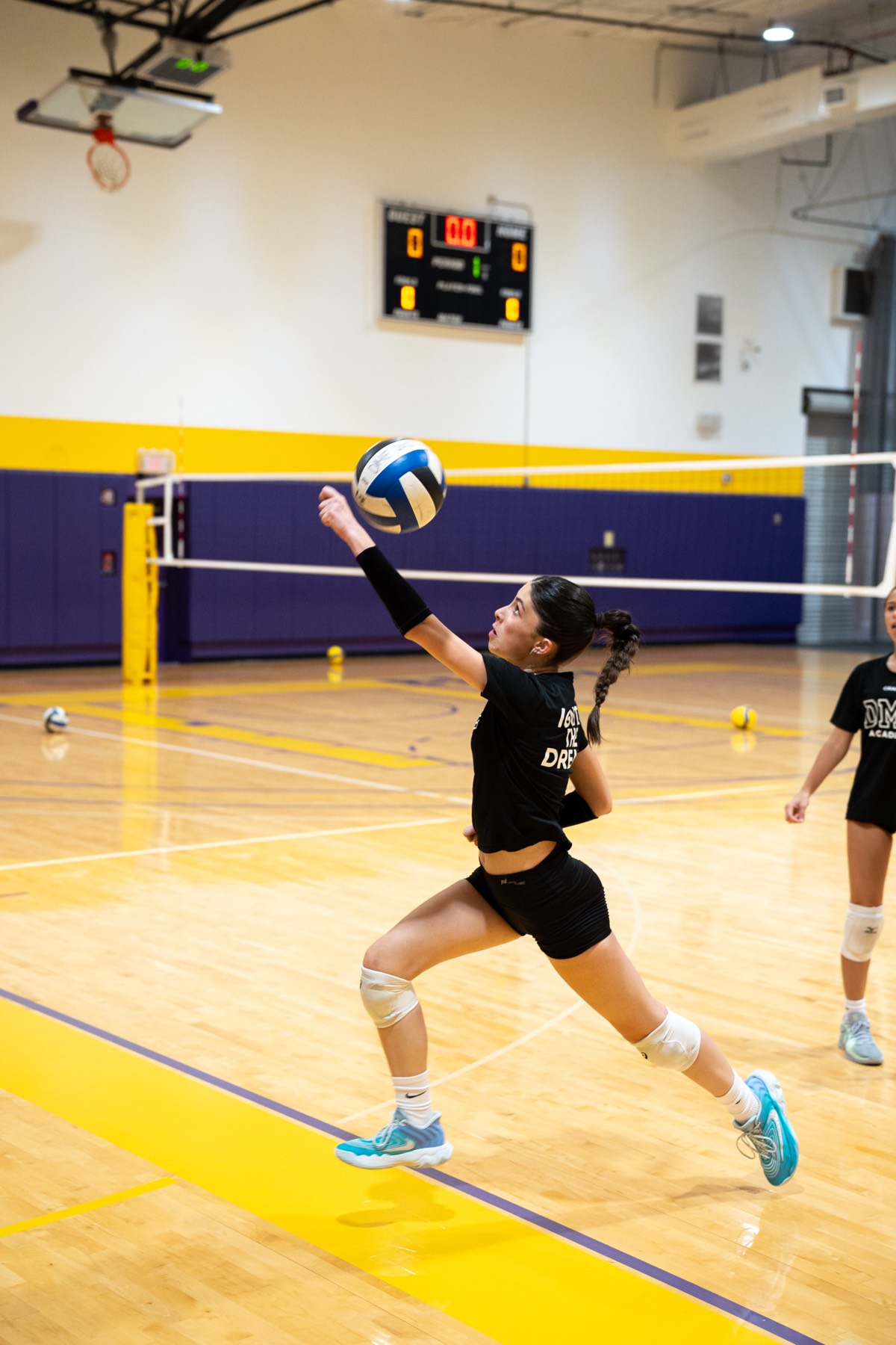Female player hitting volleyball during indoor practice